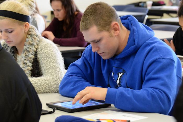 A student working on a tablet in a classroom